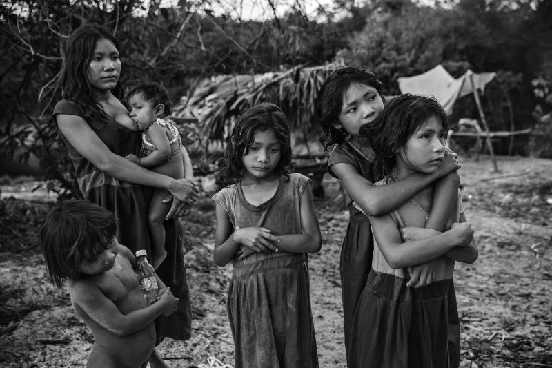 <p>Mädchen vom indigenen Stamm der Piraha stehen nahe ihrem Lager Lager am Ufer des Maici-Flusses im Bundesstaat Amazonas und beobachten Fahrer, die auf der Transamazon-Autobahn vorbeifahren, in der Hoffnung, Snacks und Limonaden gespendet zu bekommen.</p>
