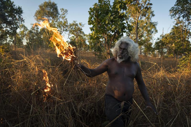 <p>Ein Aborigine brennt am Ende der Regenzeit Grasland nieder. Seit zehntausenden von Jahren brennen die Aborigines das Land strategisch nieder, um die Landschaft zu verwalten und unkontrollierte Brände zu verhindern.</p>