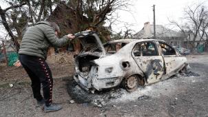 <p>Ein Mann kontrolliert ein verbranntes Auto in dem von Separatisten besetzen Gebiet in der Ostukraine.</p>