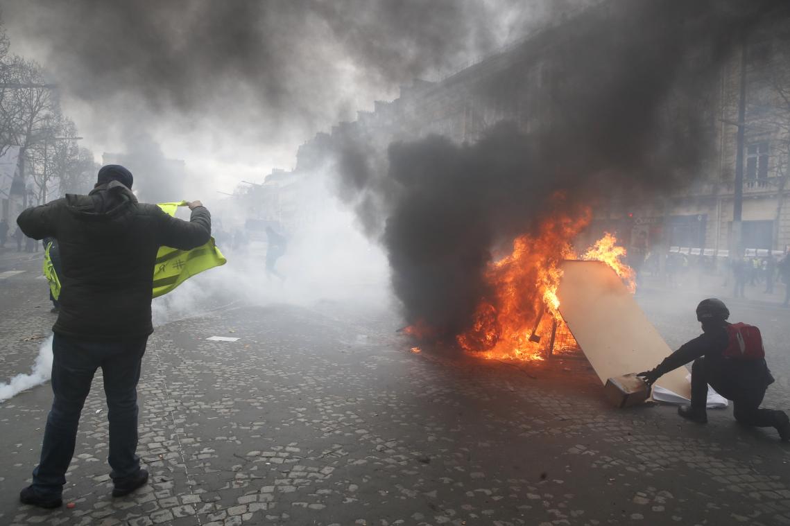 <p>Demonstranten setzen eine Barrikade bei Gelbwesten-Protesten auf den Champs-Elysees in Brand. │ Bild: dpa</p>