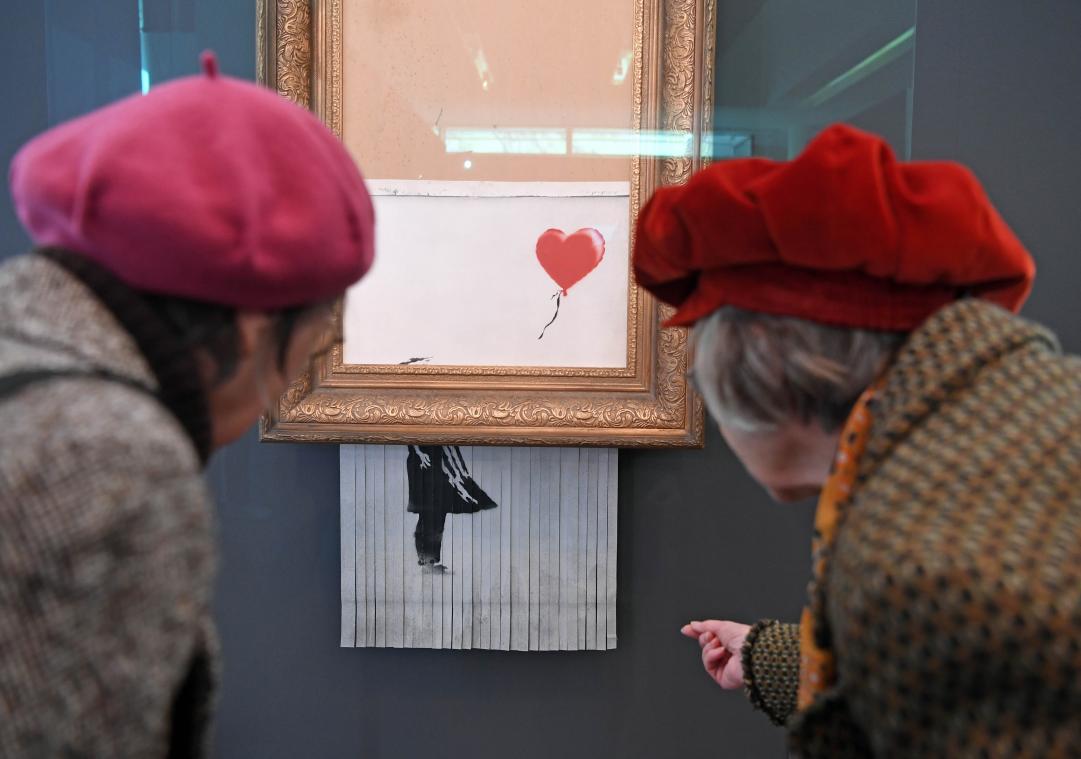 <p>Besucher betrachten das geschredderte Banksy-Bild Love is in the Bin im Museum Frieder Burda.</p>