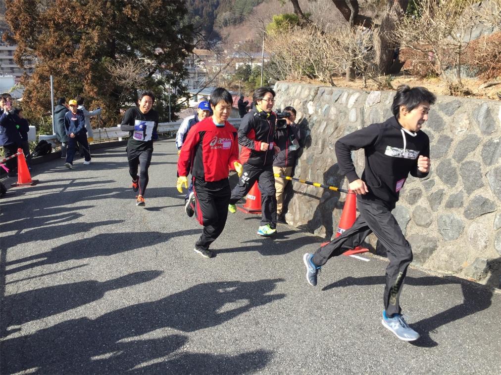 <p>Teilnehmer eines Wettlaufs rennen einen Hügel hinauf. Der Wettlauf dient als Katastrophenschutzübung für den Fall eines erneuten Tsunamis.</p>