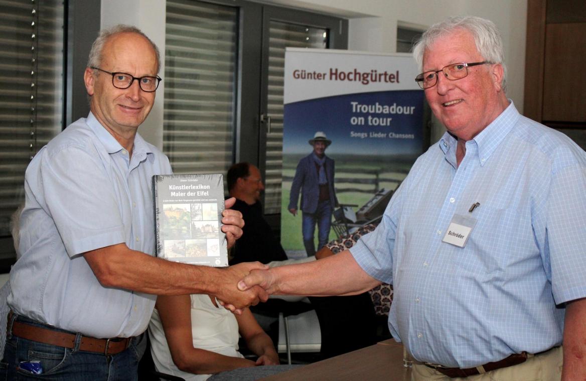 <p>Dieter Schröder (r.) überreichte Mechernichs Bürgermeister Dr. Hans-Peter Schick das erste Exemplar seines Mammutwerks „Künstlerlexikon Maler der Eifel“.</p>