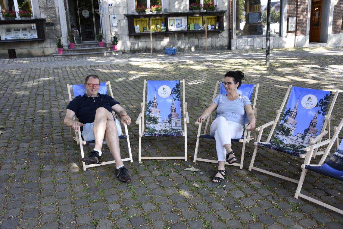 <p>Alain Brock vom Rat für Stadtmarketing und Petra Erasmi von Chic Belgique beim Probesitzen am Marktplatz. Die neuen Liegestühle sind für Personen bis 120 Kilogramm ausgerichtet. Sie werden in Ober- und Unterstadt sowie in Kettenis aufgestellt.</p>