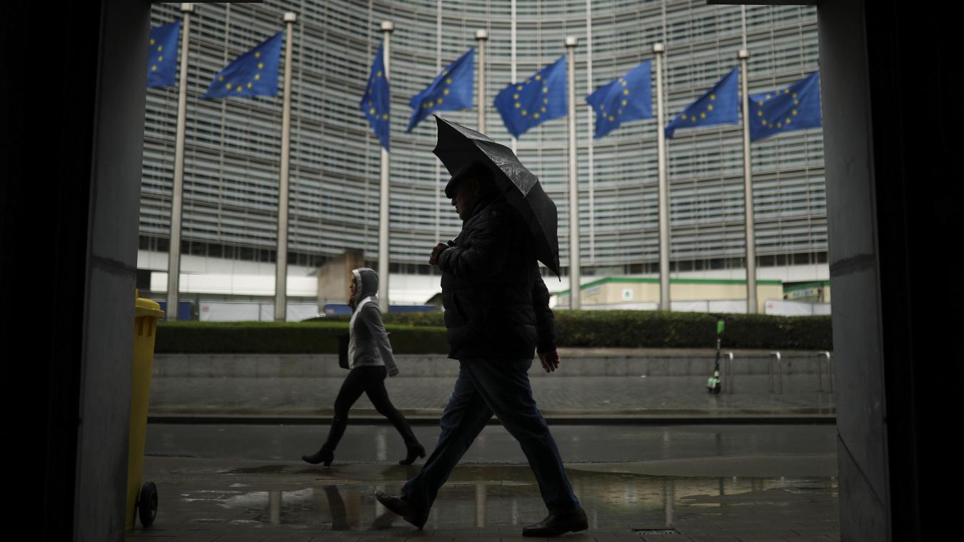 <p>Fußgänger gehen im Regen am Hauptsitz der Europäischen Kommission in Brüssel vorbei.</p>