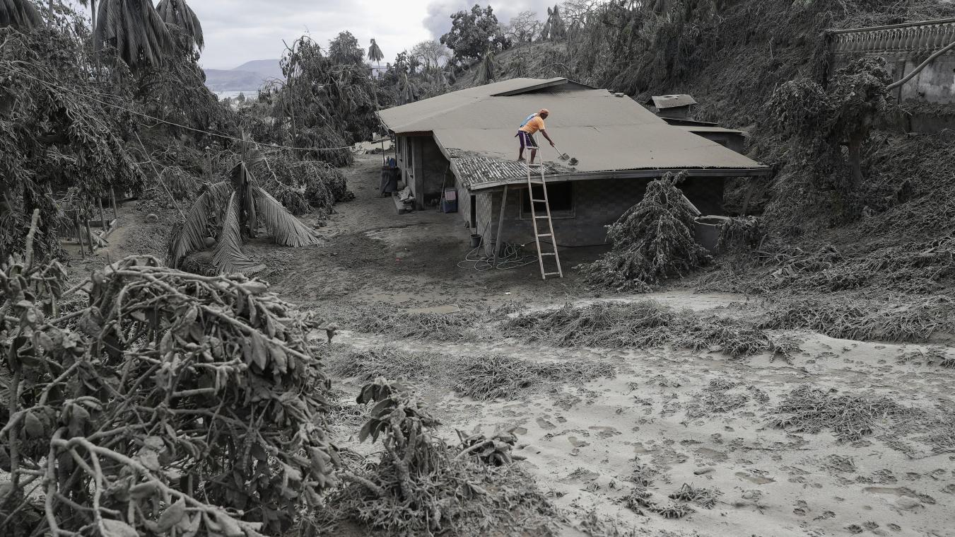 <p>Ein Mann steht in Boso-Boso in der Provinz Batangas auf dem Dach seines Hauses, um es von Vulkanasche zu befreien. Auf den Philippinen treibt der gefährliche Vulkan „Taal“ Hunderttausende Menschen in die Flucht.</p>