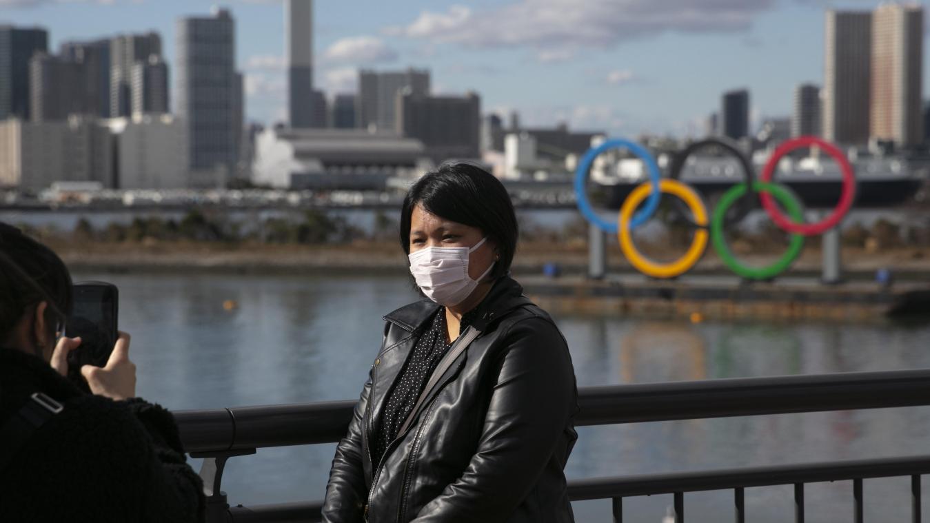 <p>Ein Tourist mit Gesichtsmaske posiert für ein Foto mit den olympischen Ringen im Hintergrund. Japan will ungeachtet der Ausbreitung des neuartigen Coronavirus wie geplant die Olympischen Spielen im Sommer austragen.</p>