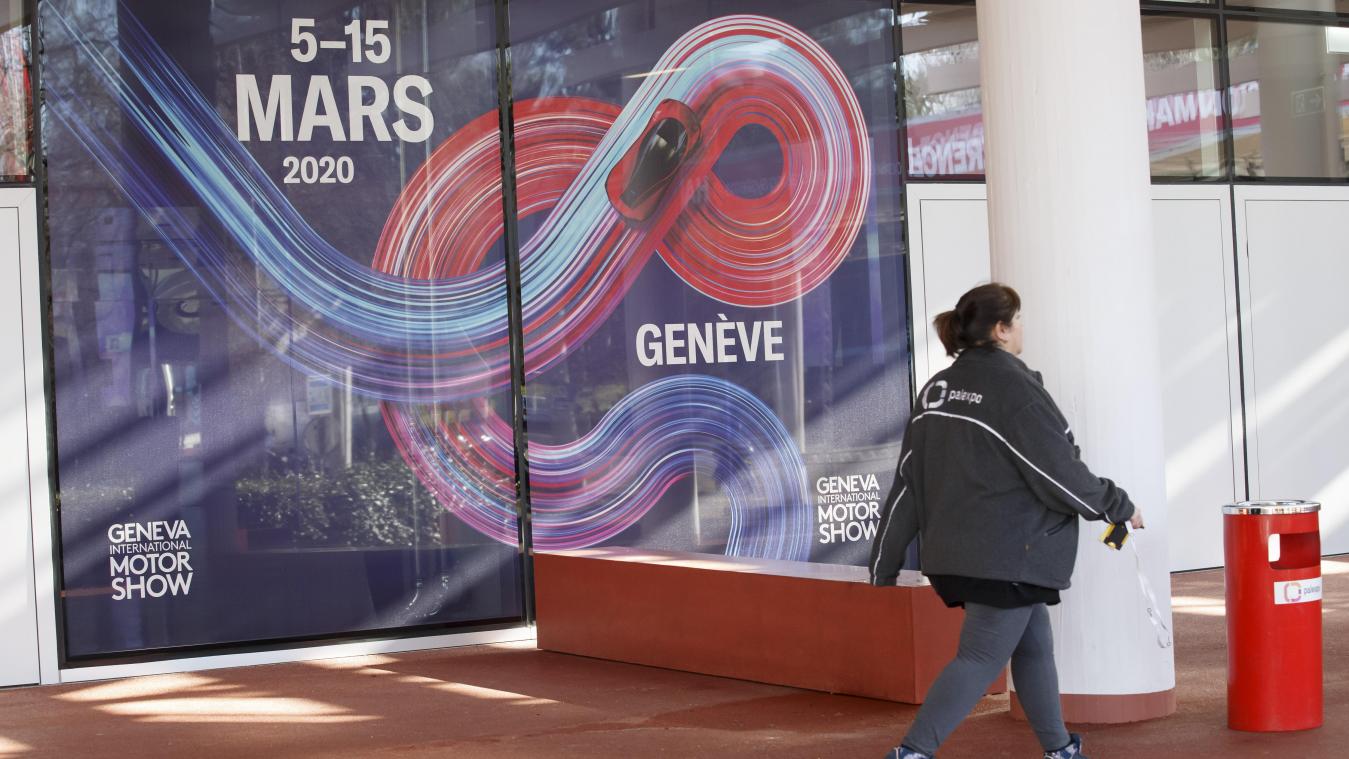 <p>Eine Arbeiterin geht an einen Banner mit Werbung zum 90. Genfer Autosalon am Veranstaltungsort Palexpo entlang.</p>