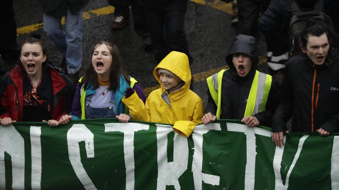 <p>Großbritannien, Bristol: Klimaschutzaktivistin Greta Thunberg (M) hält gemeinsam mit Demonstrantinnen, die Parolen rufen, einen Banner und winkt während eines Klima-Streiks.</p>