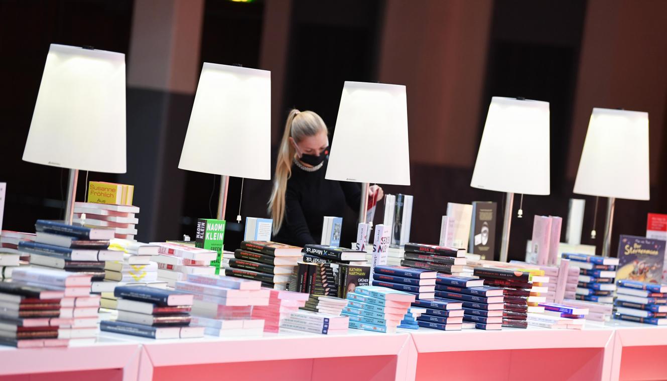 <p>Eine Mitarbeiterin der Frankfurter Buchmesse steht vor der Eröffnungspressekonferenz der Frankfurter Buchmesse an einem Buchstand in der Festhalle. Die corona-bedingte Sonderausgabe 2020 der Buchmesse findet vom 14. bis 18. Oktober statt.</p>