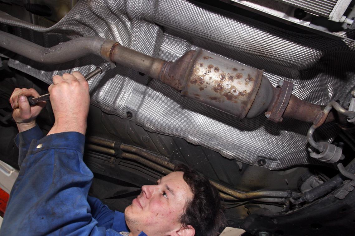 <p>Ein Automechaniker demontiert einen Rußpartikelfilter.</p>
