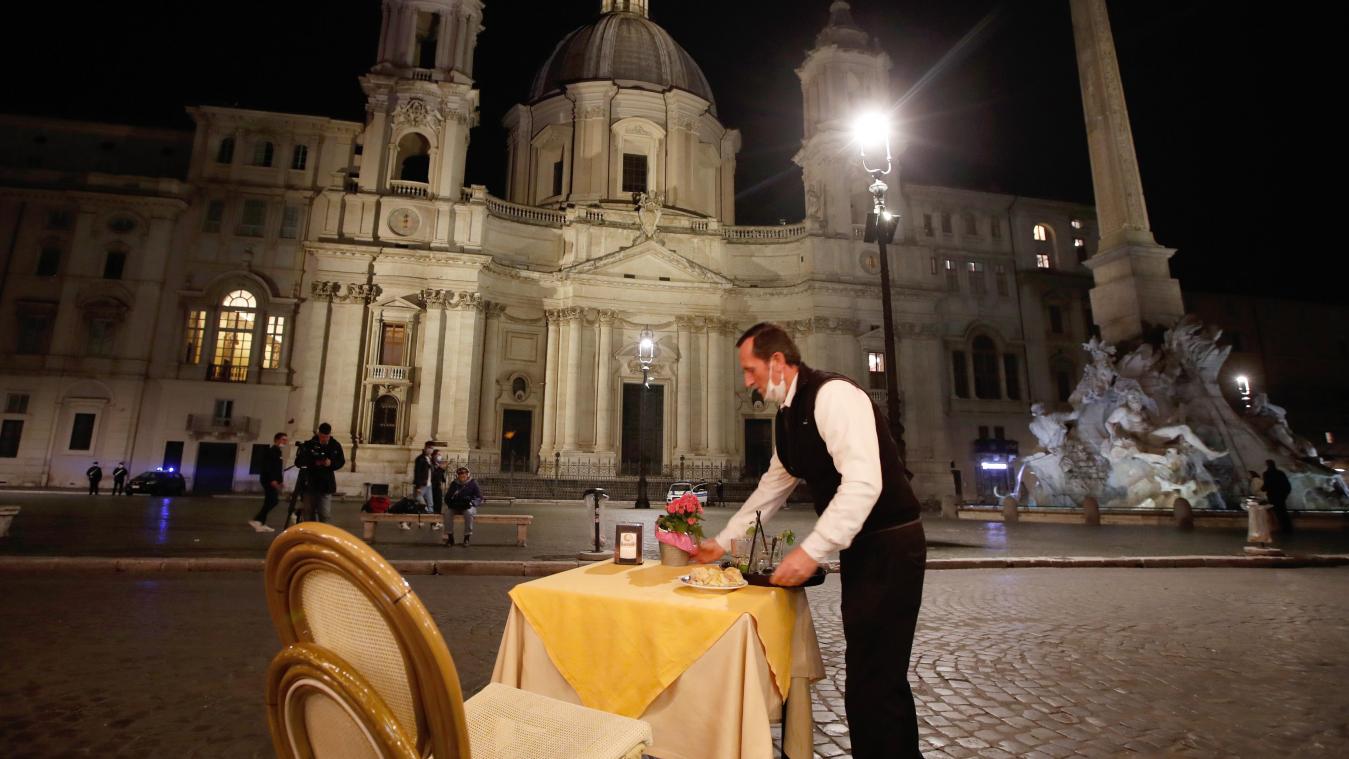 <p>Ein Kellner räumt einen Tisch in einem Café-Restaurant auf der Piazza Navona in Rom vor Beginn der Ausgangssperre ab. Unter dem Druck steigender Infektionszahlen hat Italiens Ministerpräsident Conte ein neues Paket von Maßnahmen im Kampf gegen das Coronavirus unterzeichnet.</p>