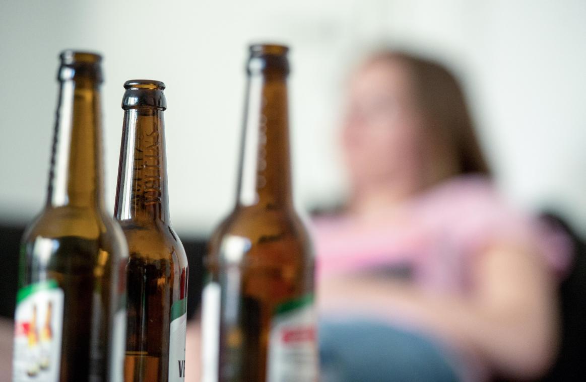<p>Eine junge Frau sitzt hinter leeren Bierflaschen. Die Corona-Pandemie verstärkt auch in Ostbelgien das Suchtverhalten. „Der Medikamenten- und Alkoholmissbrauch hat im Sommer um schätzungsweise 20 Prozent zugenommen“, sagt Yvonne Verheugen, Psychiatrie-Managerin der Klinik St. Josef in St.Vith.</p>