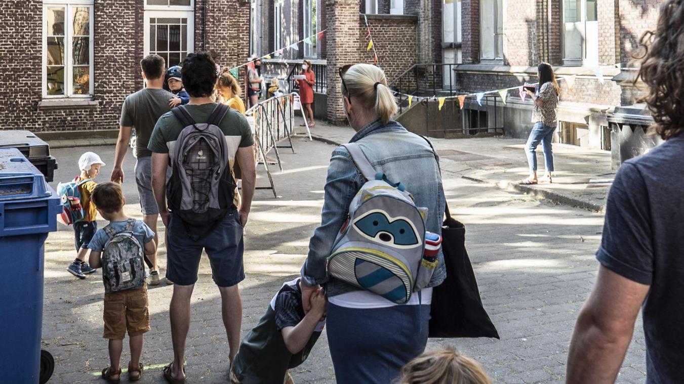 <p>Dieses Bild zeigt Kinder, die mit ihren Eltern am Eingang eines Kindergartens in Gent warten.</p>