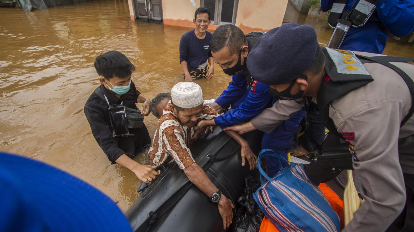 <p>Rettungskräfte helfen einem älteren Mann in einem überfluteten Dorf in ihr Boot.</p>