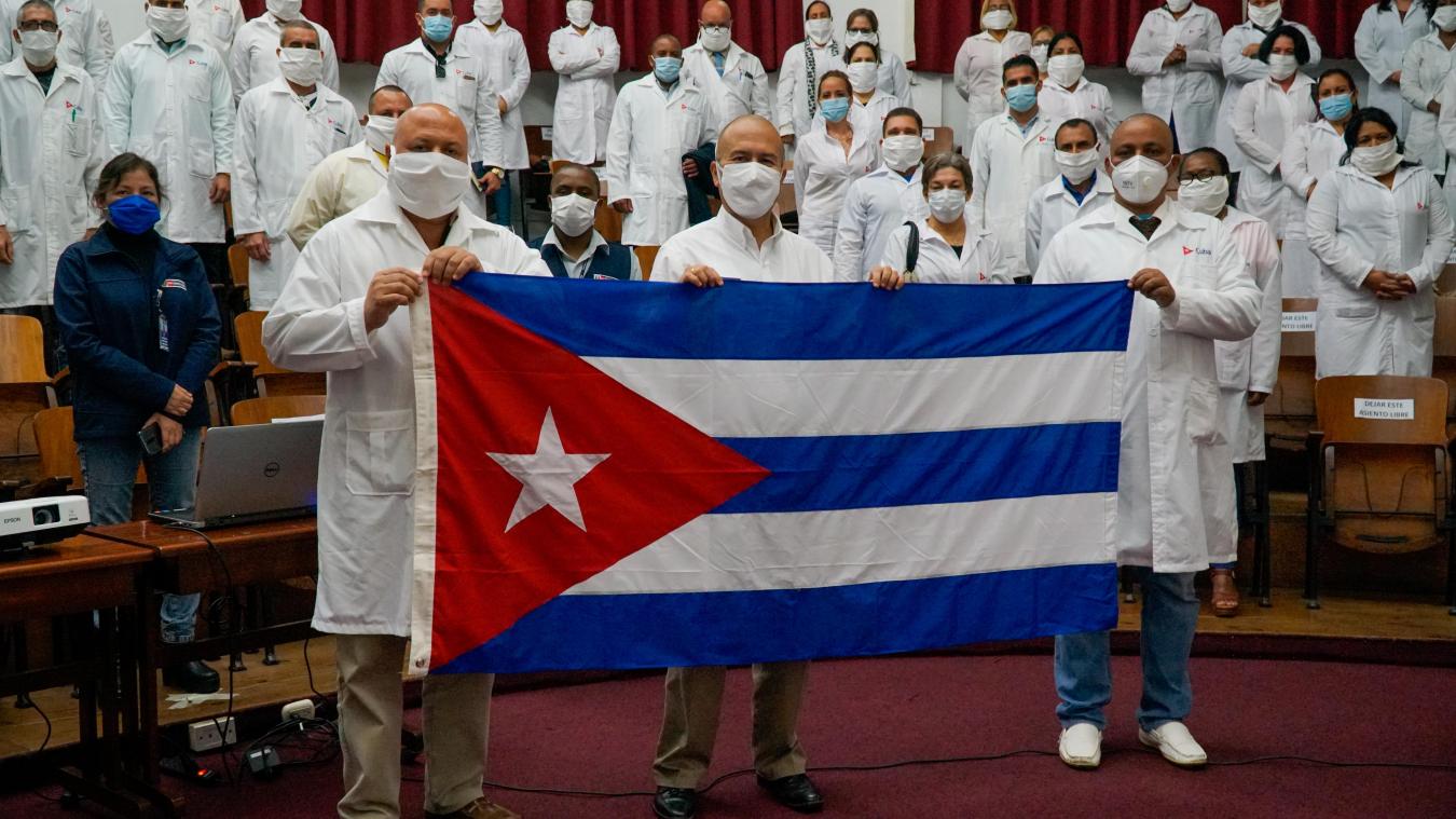 <p>Das vom peruanischen Gesundheitsministerium zur Verfügung gestellte Bild zeigt Victor Zamora (M), Perus Gesundheitsminister, der mit einer kubanischen Flagge neben kubanischen Ärzten posiert.</p>
