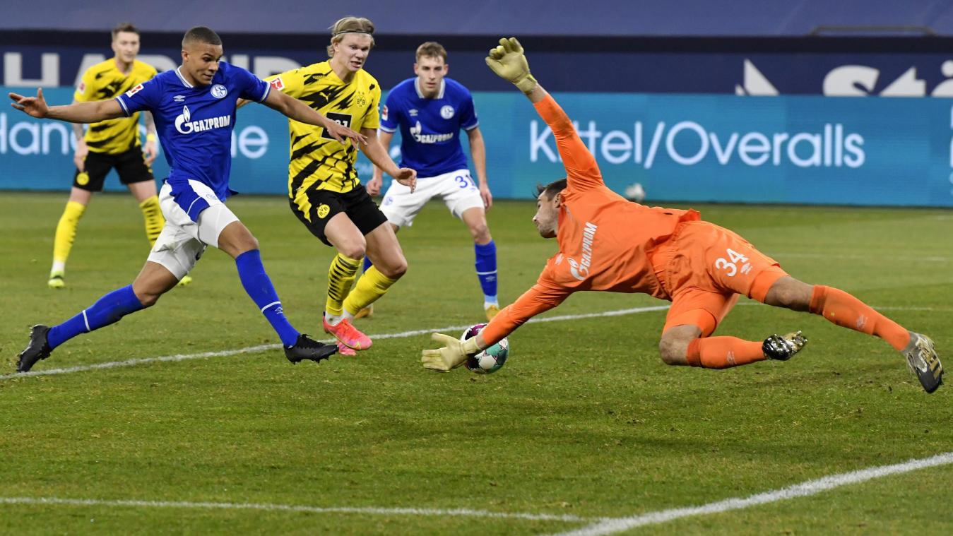 <p>Dortmunds Erling Haaland (M) schießt das Tor zum 0:4 gegen Schalkes Torwart Michael Langer (r).</p>