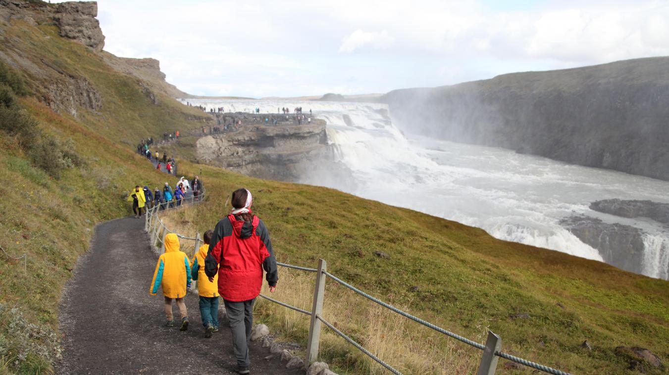 <p>Touristen wandern zum isländischen Wasserfall Gullfoss.</p>