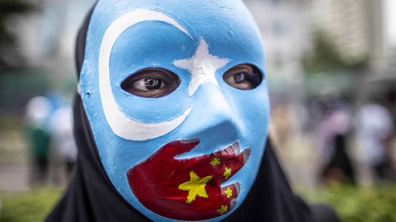 <p>Ein Demonstrant trägt aus Solidarität mit den Uiguren eine Maske mit den Farben der Flagge der uigurischen Unabhängigkeitsbewegung und einer aufgemalten roten Hand mit den Sternen der chinesischen Nationalflagge.</p>