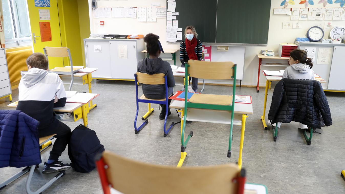 <p>Eine Lehrerin mit Mundschutz unterrichtet in Straßburg Kinder unter Einhaltung des Mindestabstands.</p>