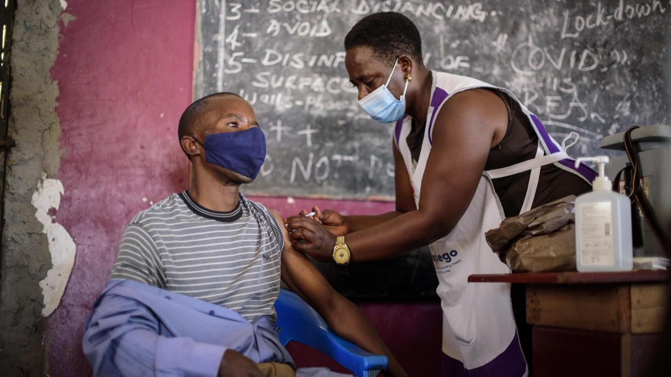 <p>Kisenyi, Uganda: Eine Krankenschwester verabreicht einem jungen Mann eine Impfung gegen das Coronavirus vor einer Tafel mit Tipps zum Schutz vor einer Ansteckung mit dem Coronavirus.</p>