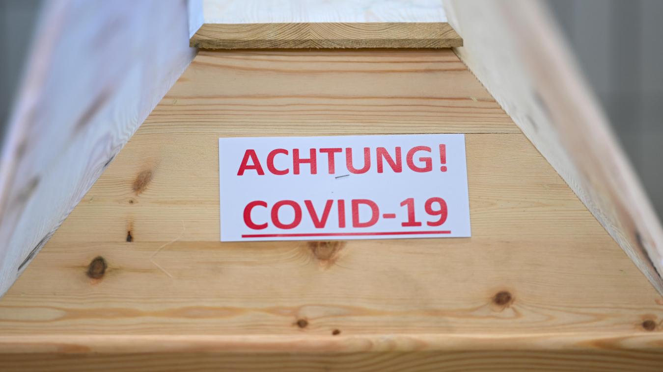 <p>Ein Sarg mit der Aufschrift „Achtung! Covid-19“ steht in einem Raum im Krematorium, bevor der Sarg eingeäschert wird.</p>