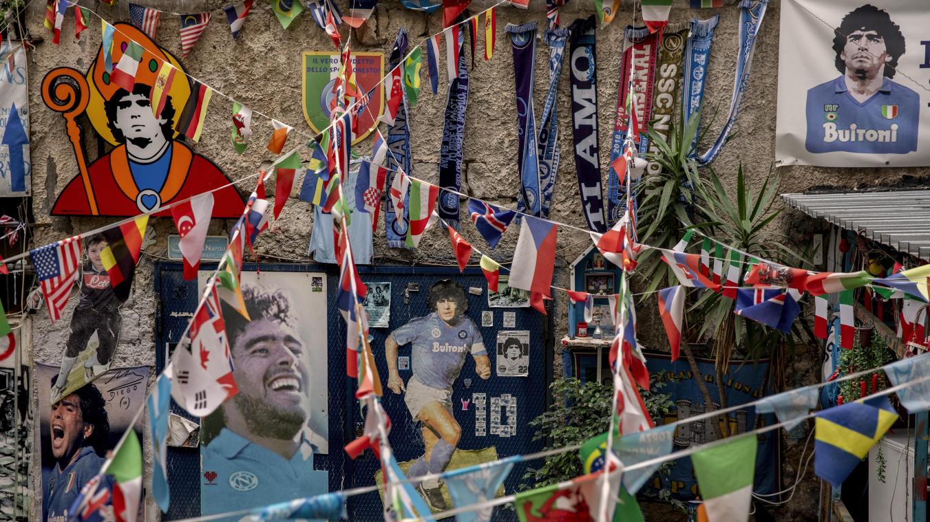 <p>Bilder der Fußballlegende Maradona hängen neben Fähnchen in den Spanischen Vierteln in Neapel.</p>