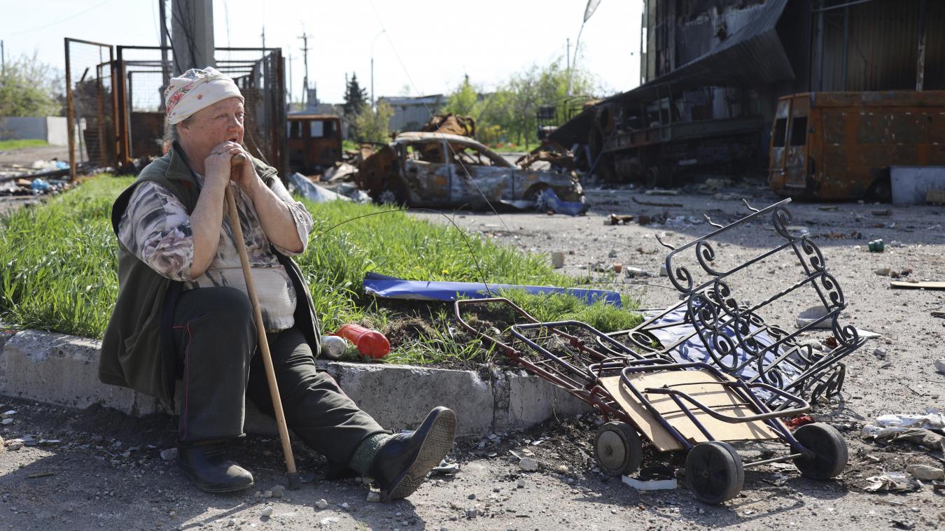 <p>Eine Frau sitzt neben zerstörten Autos in einem Gebiet unter der Regierung der Donezker Volksrepublik im Osten der Ukraine.</p>