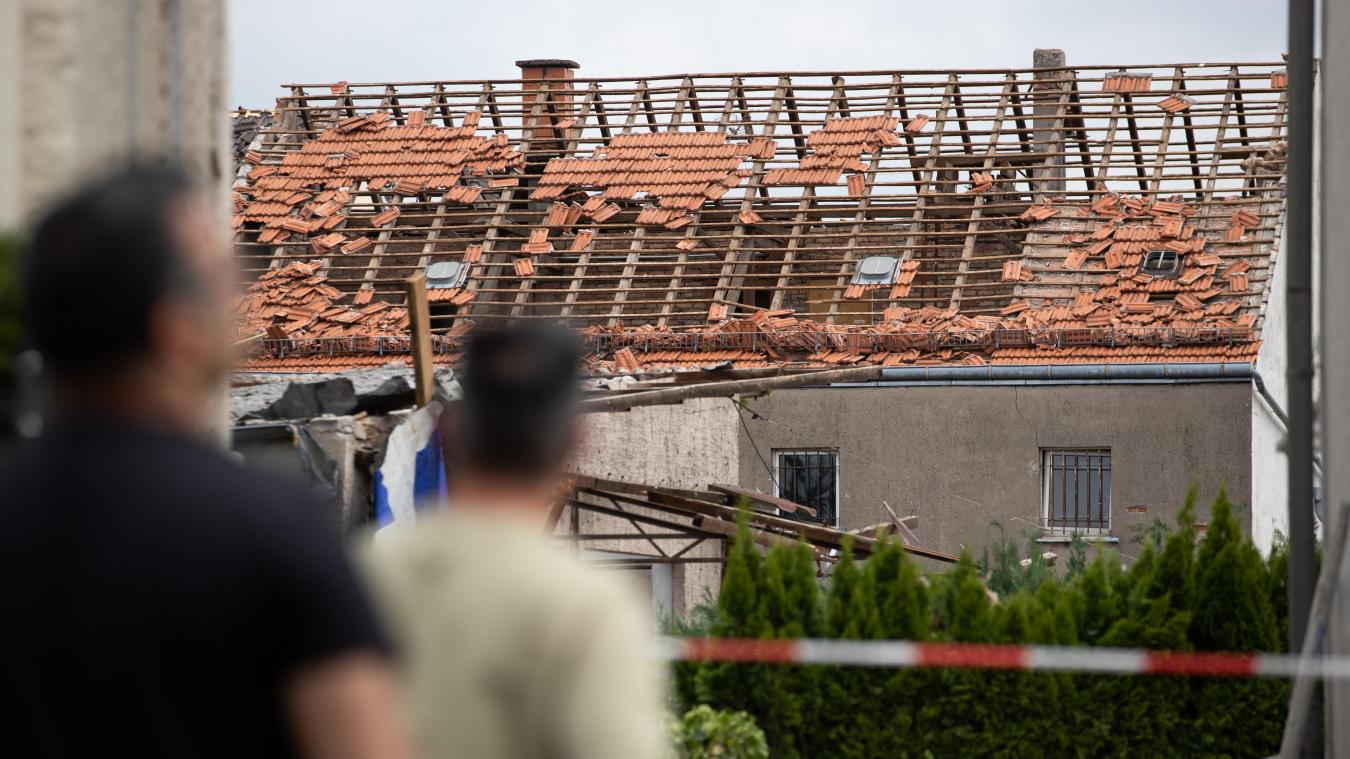 <p>Anwohner blicken auf das beschädigte Dach eines Hauses: Ein Tornado hat in Paderborn und Lippstadt am Freitagnachmittag massive Schäden verursacht.</p>