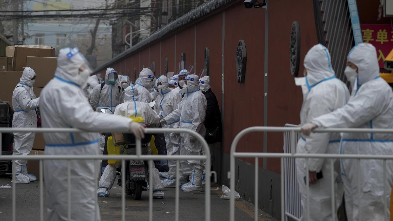 <p>Arbeiter in Schutzanzügen stehen an einer Barrikade Wache in Peking. Eine Rekord-Welle neuer Corona-Infektionen führt in China zu immer größeren Einschränkungen für die Bevölkerung.</p>