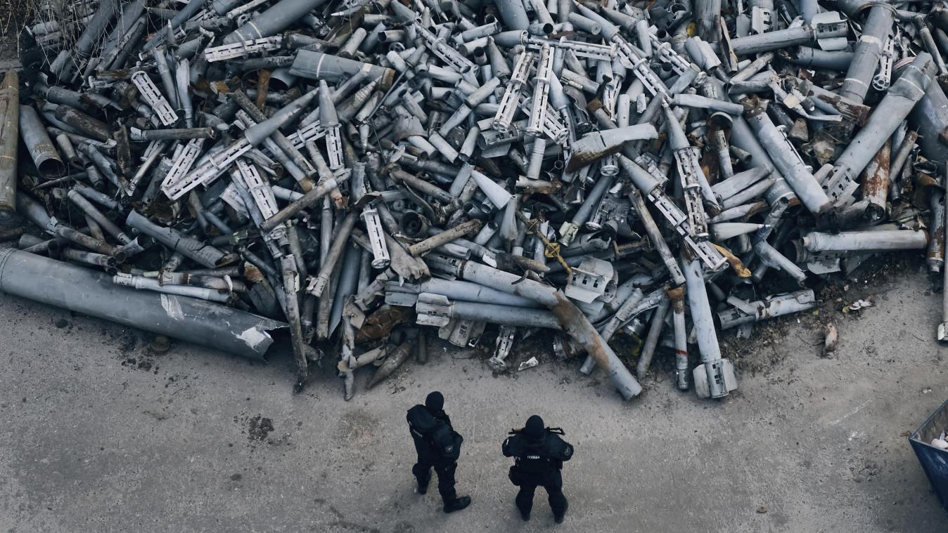 <p>Polizeibeamte betrachten die eingesammelten Fragmente von Raketen, die in Charkiw eingeschlagen sind.</p>