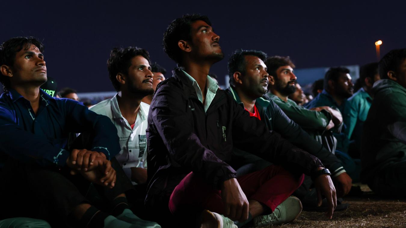 <p>Arbeiter, überwiegend aus Indien, Bangladesch, Nepal und anderen ärmeren Ländern Asiens, verfolgen im „Asian Town Cricket Stadium“ das Spiel Argentinien-Australien auf einer Großbildlwand.</p>