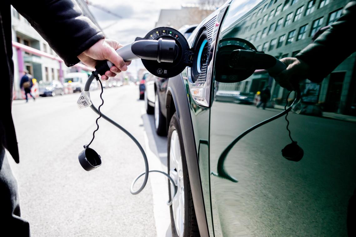 <p>Ein Mann entfernt an einem Auto mit Plug-in-Hybrid-Antrieb den Stecker: Die Belgier sind noch nicht zu 100 Prozent von den neuen E-Mobilen überzeugt.</p>