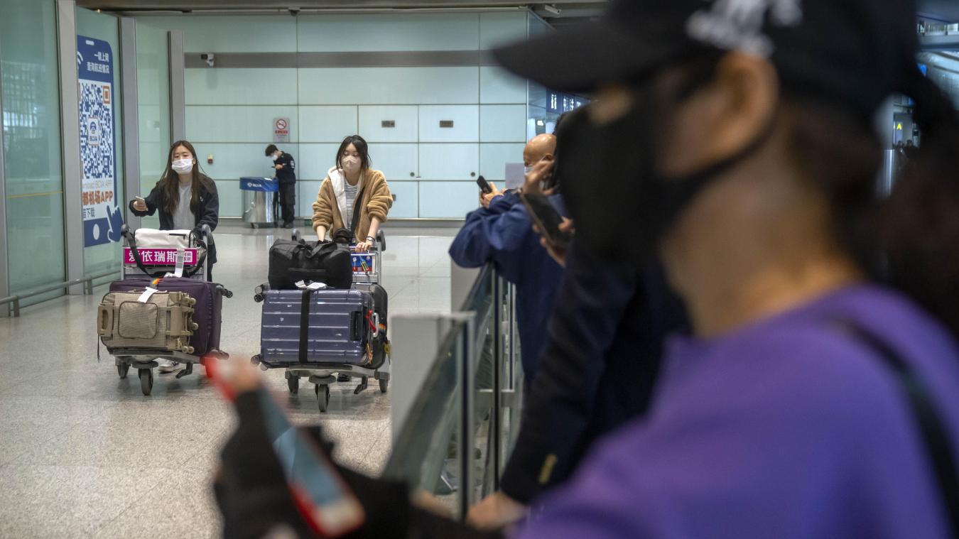 <p>Reisende mit Mund-Nasen-Schutz gehen durch den Ankunftsbereich für internationale Flüge am Beijing Capital International Airport.</p>