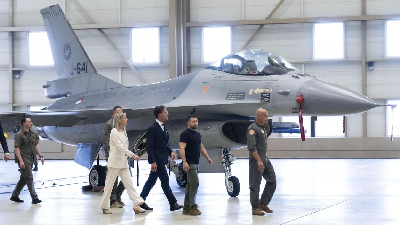 <p>Wolodymyr Selenskyj (2.v.r), Präsident der Ukraine, und Mark Rutte (m.), Ministerpräsident der Niederlande, laufen an einem F-16 Kampfjet vorbei.</p>
