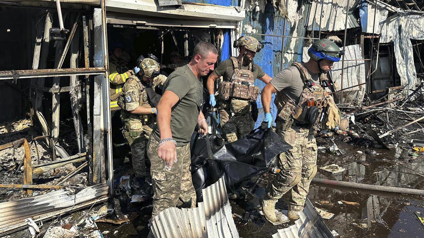 <p>Auf diesem von der Pressestelle der ukrainischen Polizei zur Verfügung gestellten Foto tragen Soldaten und Rettungskräfte die Leiche eines Opfers nach einem russischen Raketenangriff auf einen Markt in der Region Donezk.</p>