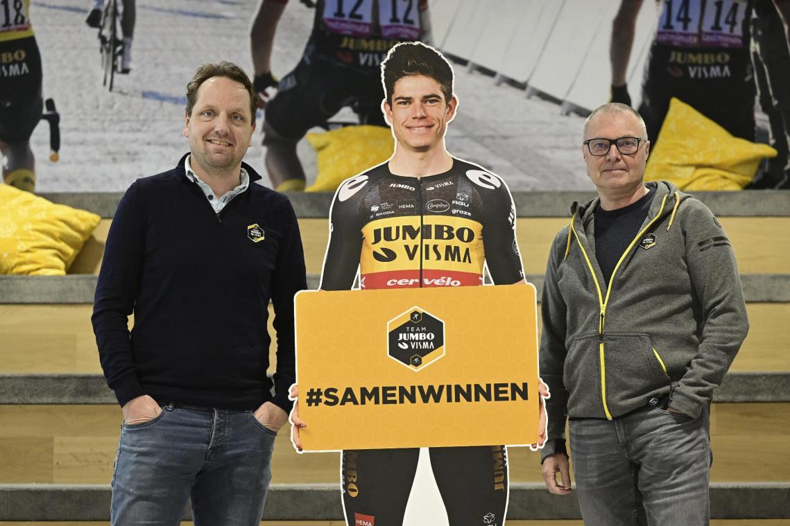 <p>Jumbo-Visma-Sportdirektor Merijn Zeeman und der Trainer von Wout van Aert, Marc Lamberts, posieren mit einem lebensgroßen Aufsteller des Ausnahmefahrers.</p>