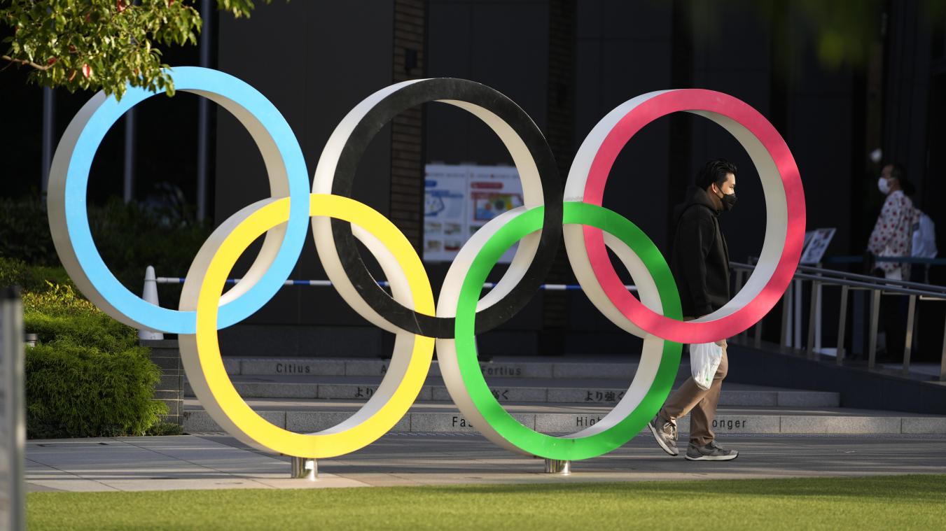 <p>Menschen gehen an den olympischen Ringen, die in Tokiovor dem Japanischen Olympischen Museuminstalliert sind, vorbei.</p>