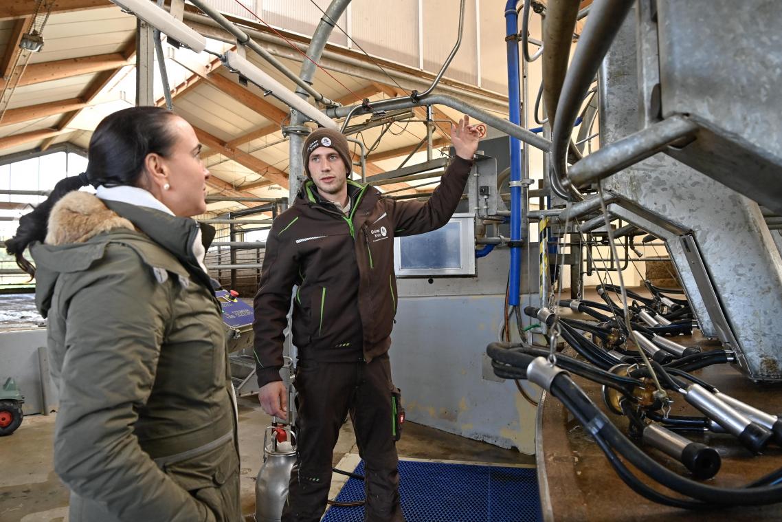 <p>Der Raerener Landwirt Philipp Cróe erklärt Lydia Klinkenberg die Funktionsweise der Melkmaschine.</p>