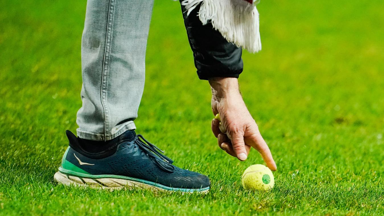<p>Ein Helfer hebt einen Tennisball vom Spielfeld in Kaiserslautern auf.</p>