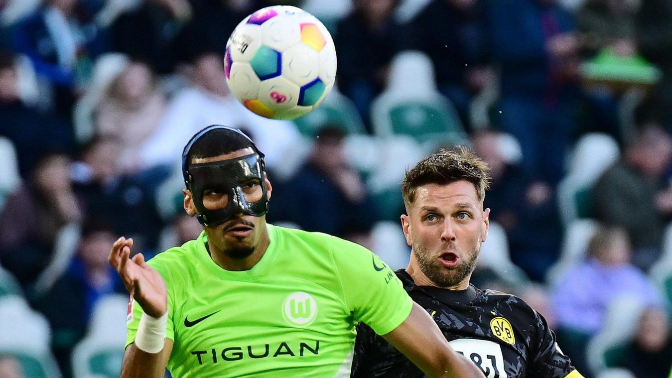 <p>Kopfballduell: Dortmunds Torschütze Niclas Füllkrug (rechts) gegen Wolfsburgs Maskenmann Moritz Jenz.</p>