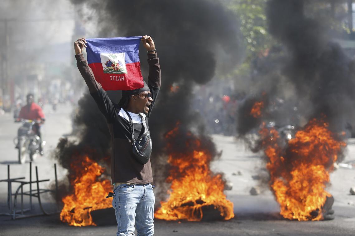 <p>Ein Demonstrant hält eine haitianische Flagge während Protesten für den Rücktritt von Premierminister Henry hoch.</p>
