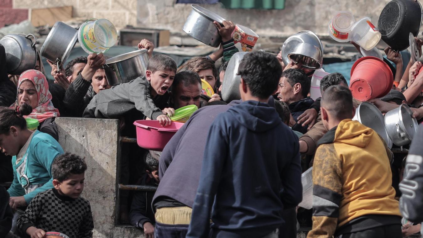 <p>Palästinenser warten an einer Spendenstelle in einem Flüchtlingslager im südlichen Gazastreifen auf Lebensmittel.</p>