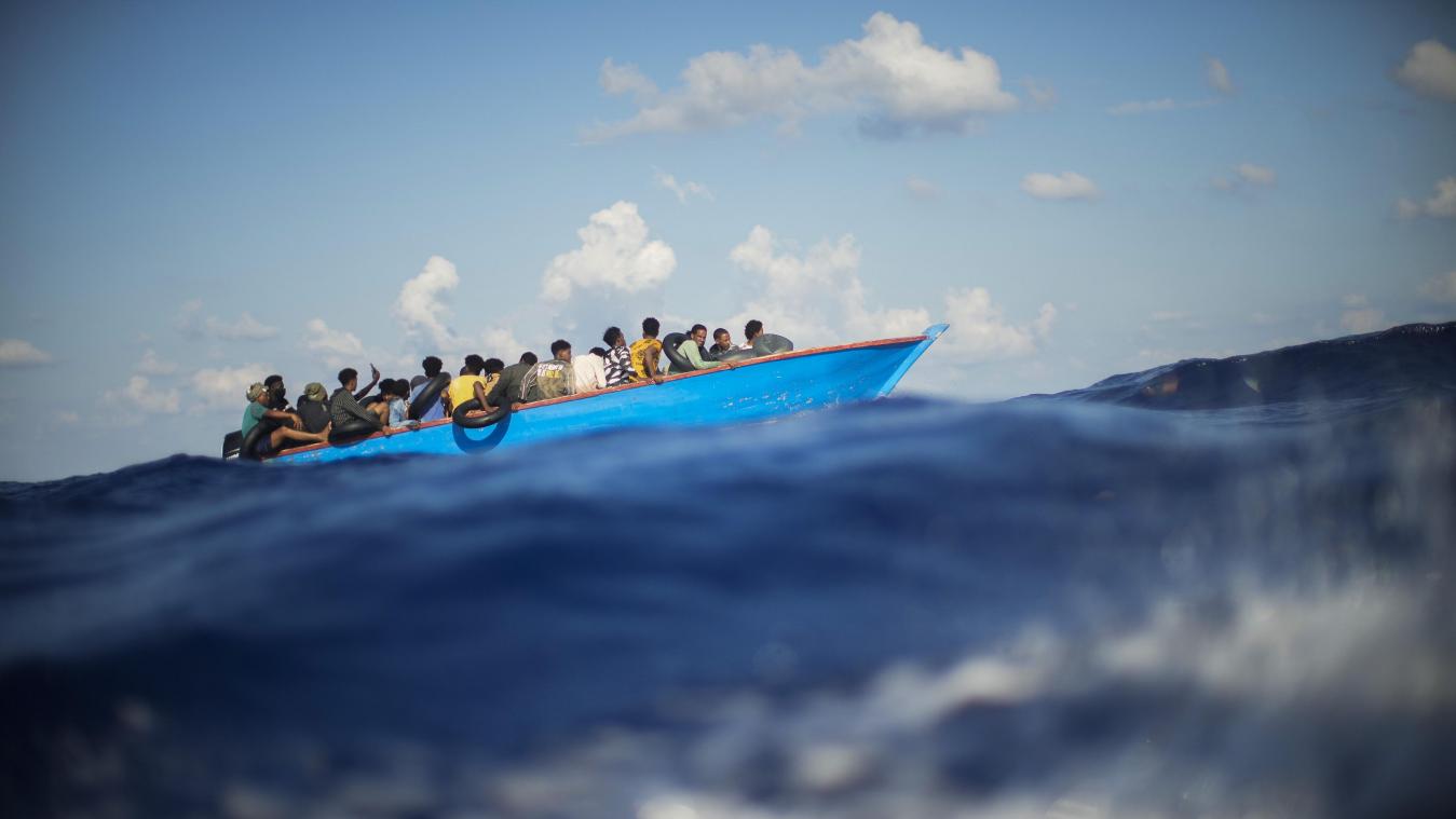 <p>Migranten sitzen in einem Holzboot im Mittelmeer nahe der Insel Lampedusa.</p>