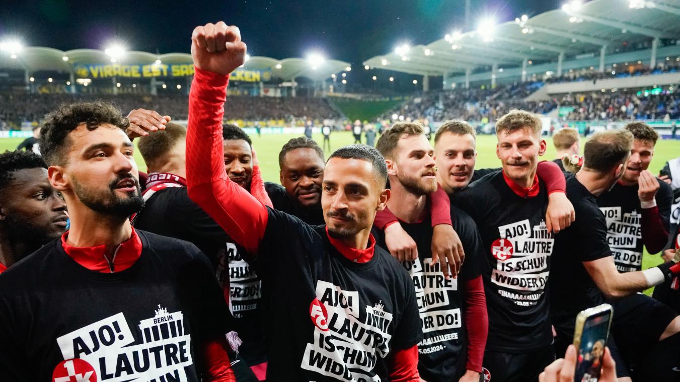 <p>Kaiserslauterns Spieler tragen T-Shirts mit der Aufschrift „Ajo! Lautre is schun widder do!“ und feiern nach dem Schlusspfiff.</p>
