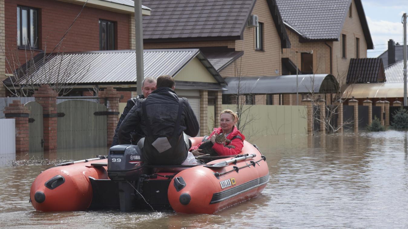 <p>Zwei Anwohner bringen in Orenburg eine Frau und ihr Haustier mit einem Boot aus einer überfluteten Straße.</p>