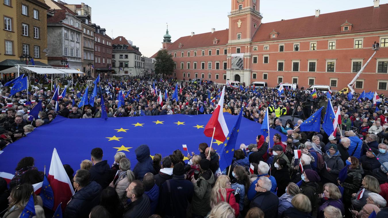 <p>Menschen schwenken EU- und polnische Fahnen zur Unterstützung der polnischen EU-Mitgliedschaft während einer Demonstration.</p>