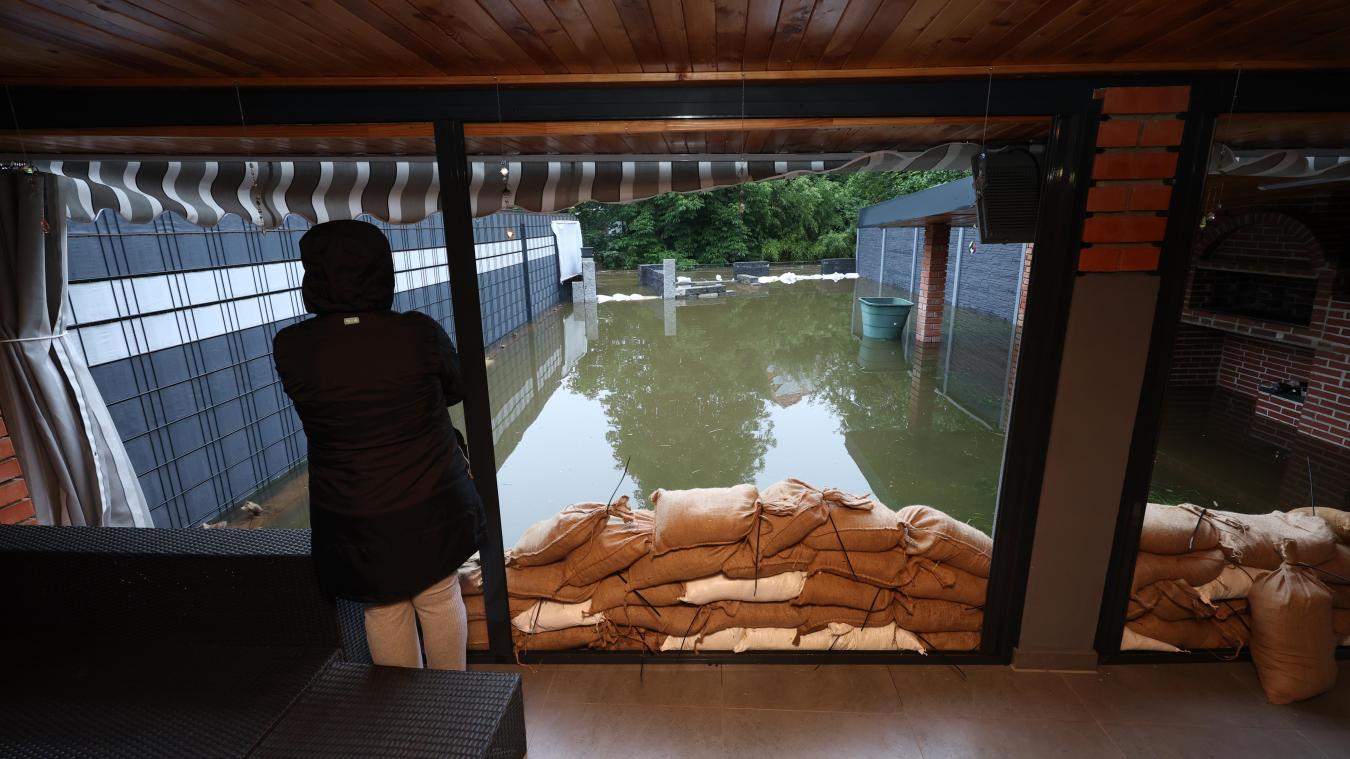 <p>Eine Frau steht in Burgau in einem Wintergarten vor ihrem vom Hochwasser der Mindel überfluteten Garten.</p>