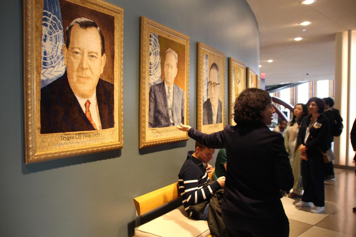 <p>Eine Tour-Führerin zeigt ihrer Gruppe eine Reihe von Tapisserie-Porträts der Generalsekretäre der UN-Geschichte im Hauptsitz der Vereinten Nationen in New York.</p>