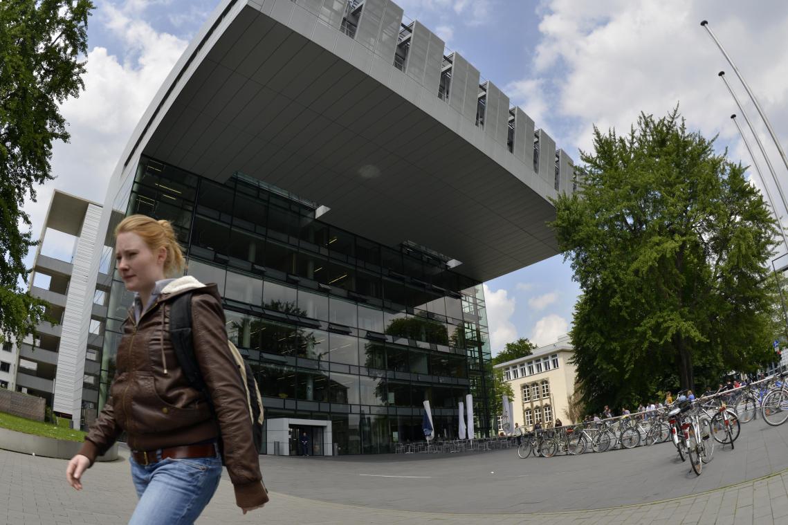 <p>Eine junge Frau geht am Studien-Service-Zentrum der Rheinisch-Westfaelische Technische Hochschule Aachen (RWTH) Aachen vorbei.</p>